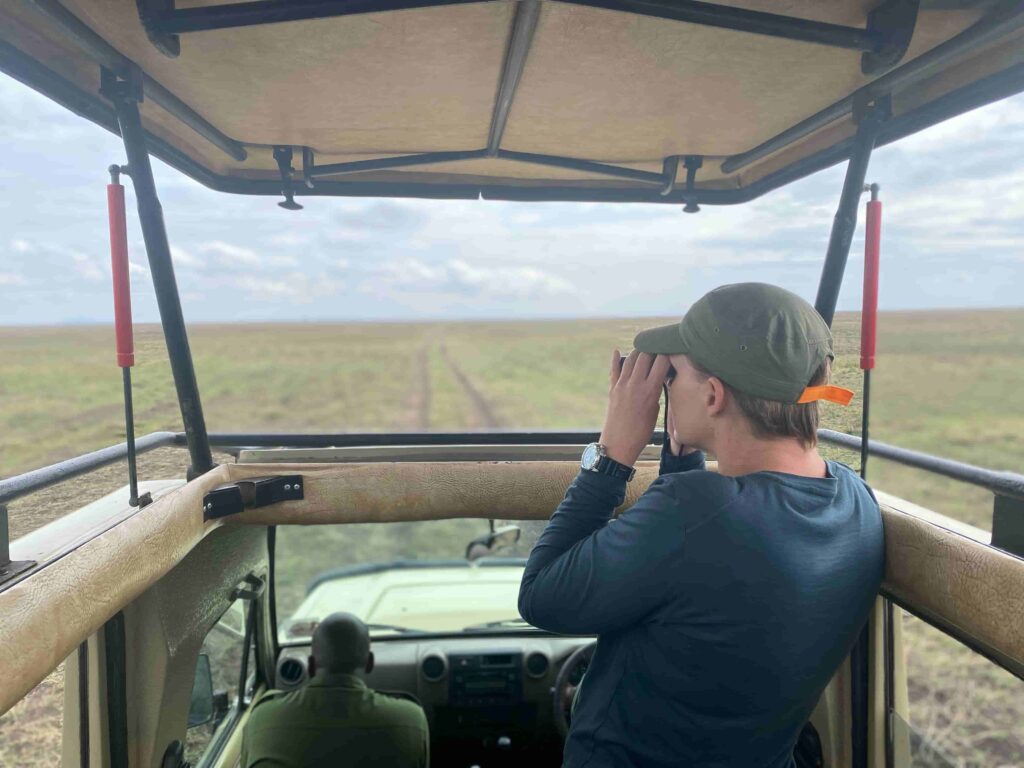 kjiken door verrekijker vanuit safari wagen